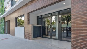 A modern building with a brick facade, large glass entrance doors, and a visible fire escape on the left. - Safety and comfort: 2 beds, up to 3 people. New (Campos Elíseos São Paulo)