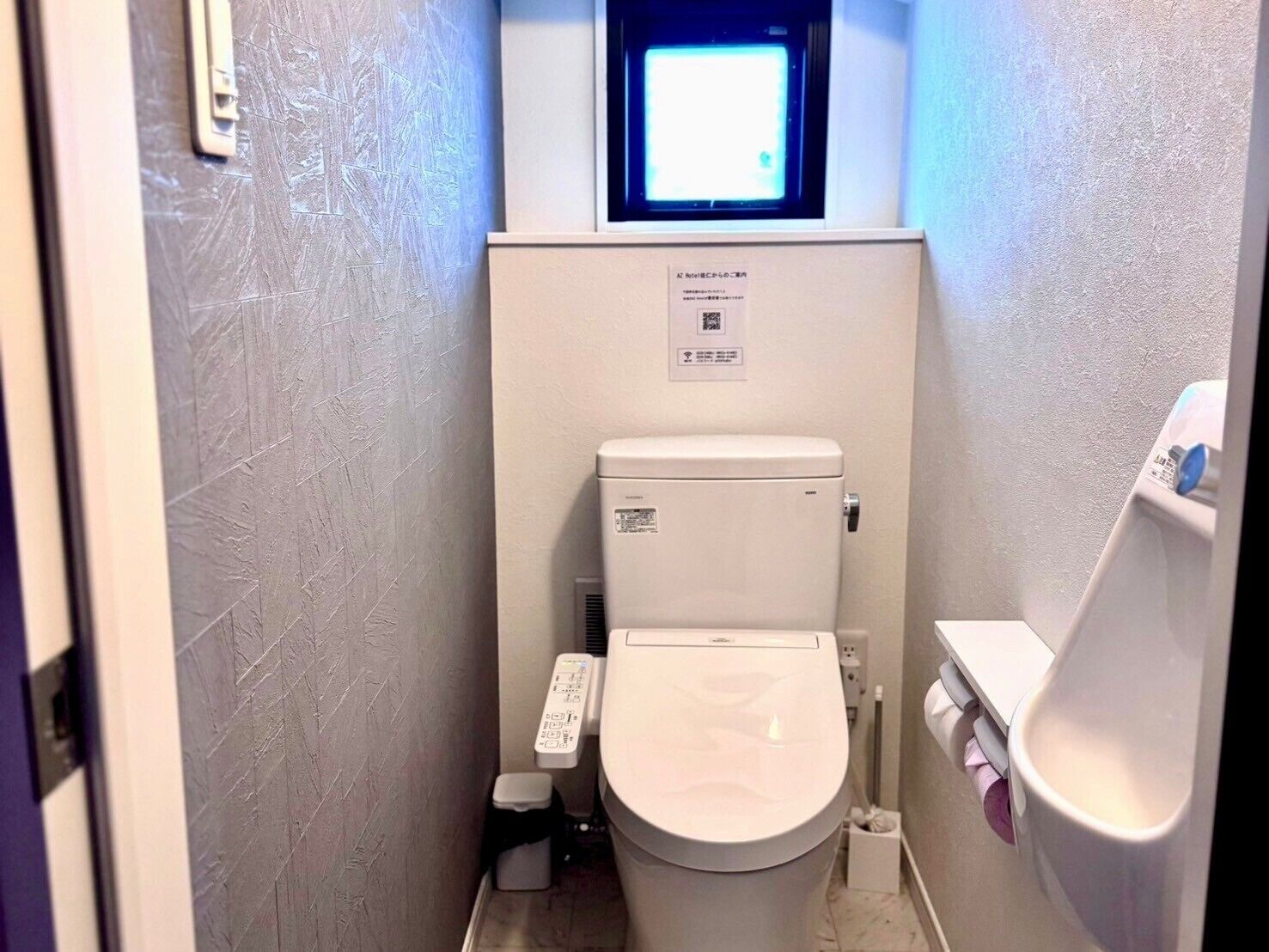 Un baño pequeño y funcional con inodoro, secamanos y lavabo.