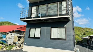 A two-story building with a balcony on the upper floor. - AZ Hotel Ocean View (Amami)