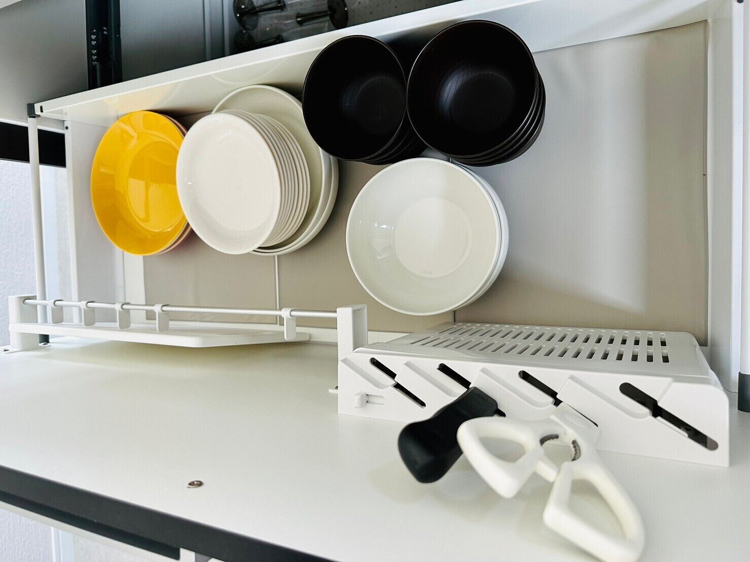 A kitchen with a utensil holder and a dish rack.
