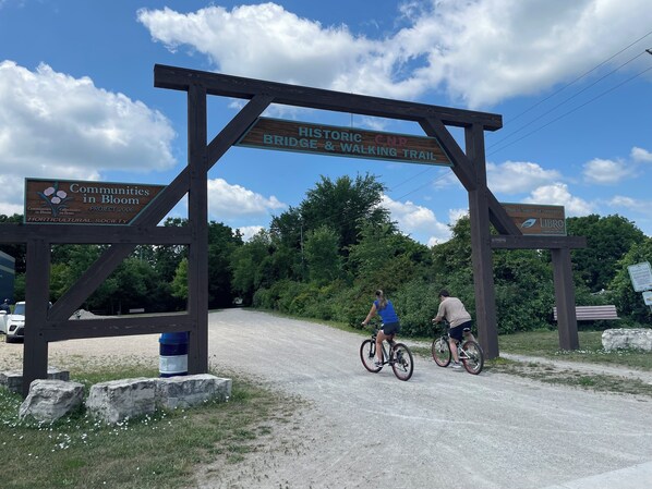 Un arco de madera con carteles que indican el Puente Histórico y el Sendero para Senderistas, y el Proyecto Communities in Bloom 2006.