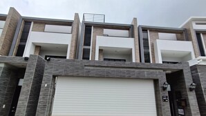 A multi-story building with a garage door, balconies, and a modern architectural design. - SeaWave (Magong)