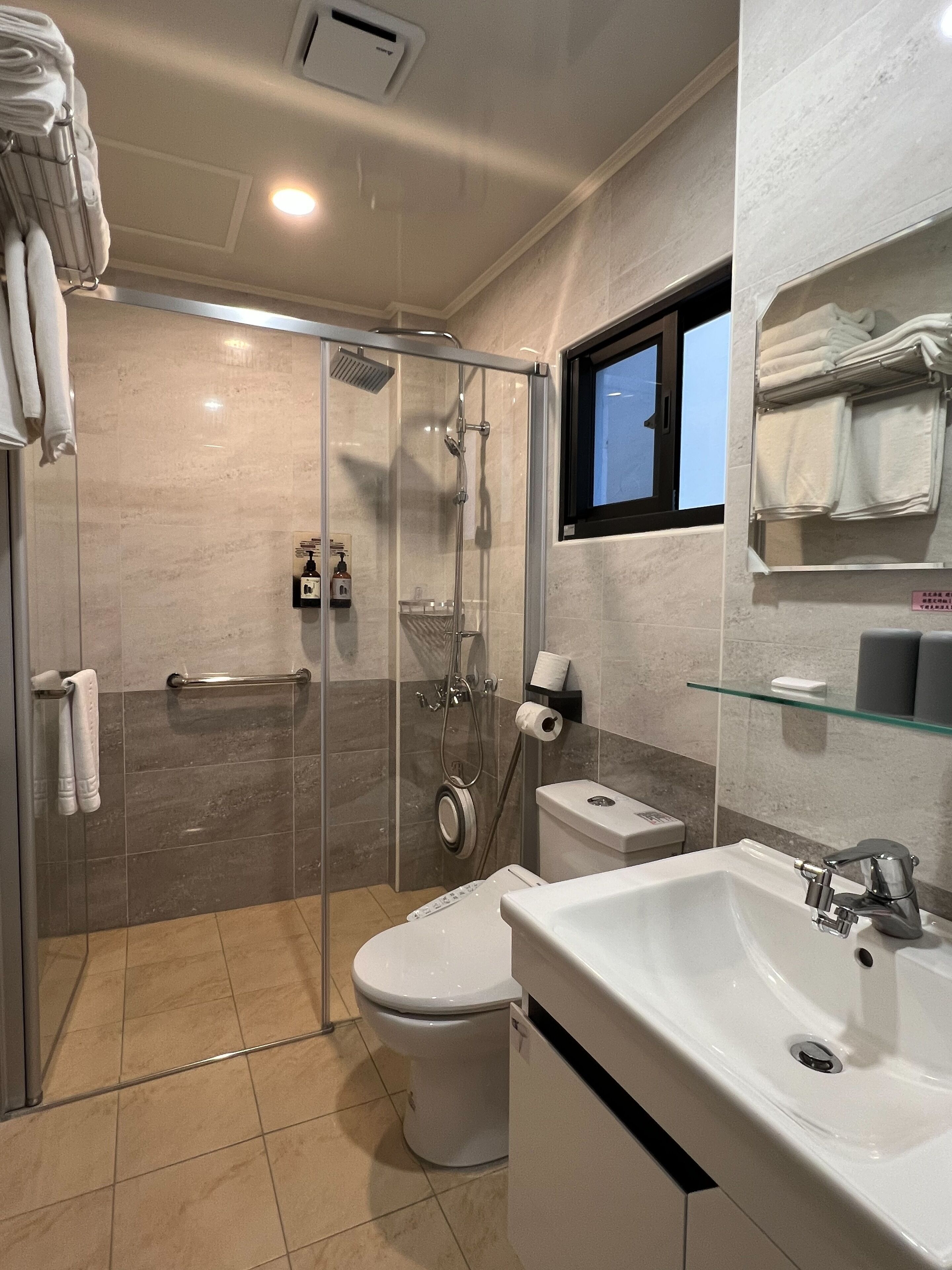 Une salle de bain moderne avec une douche à parois de verre, des toilettes et un lavabo.