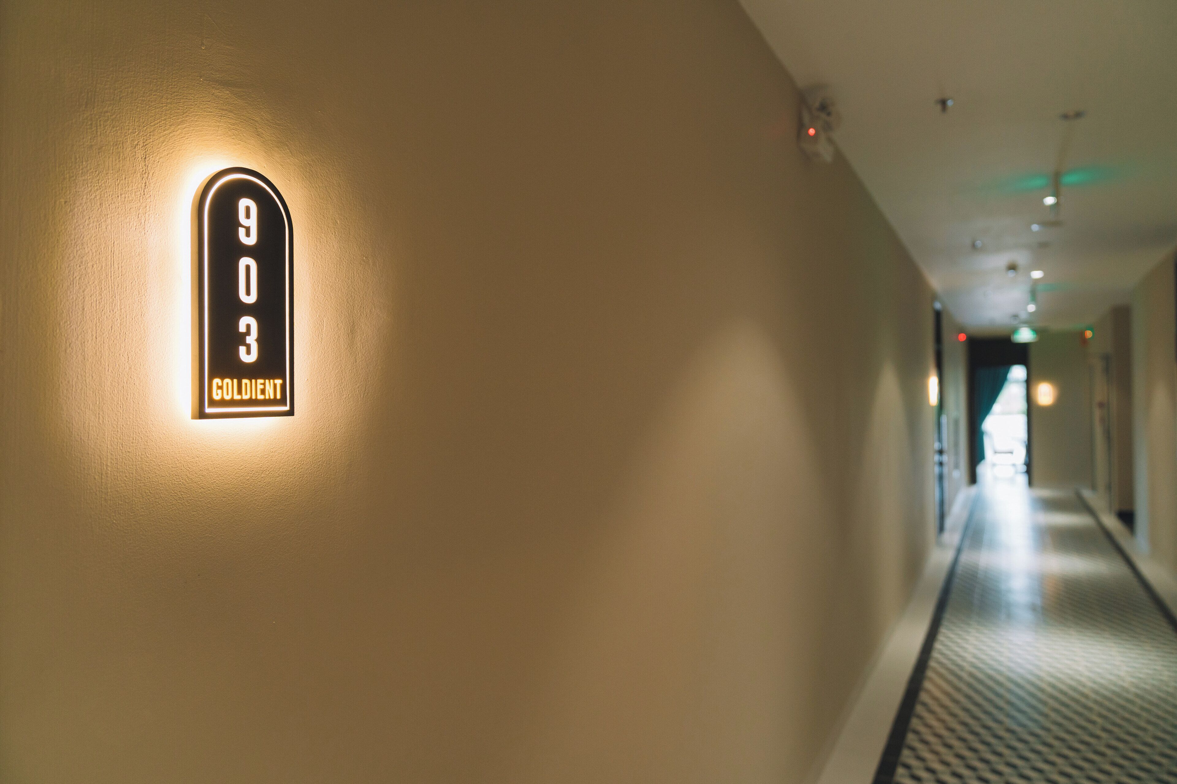 A hallway with a lit-up sign reading "903 GOLDENT".