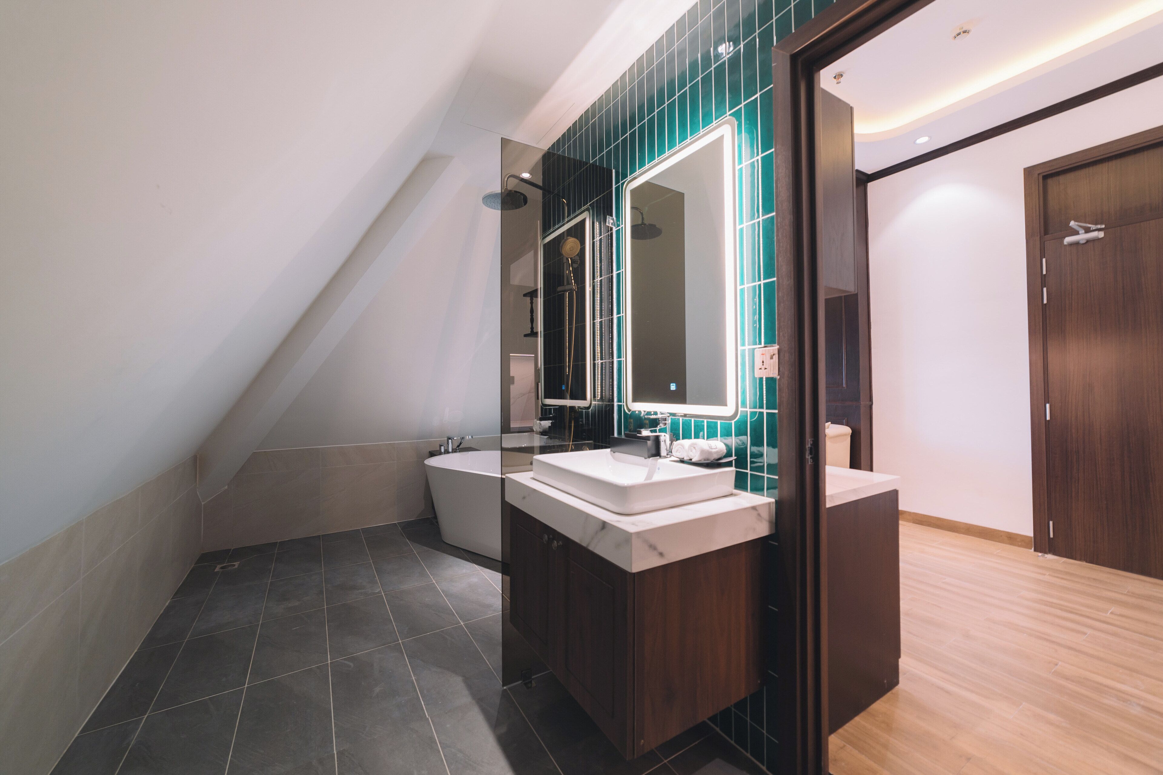 A modern bathroom with a freestanding bathtub, a vanity with a mirror, and a shower area.