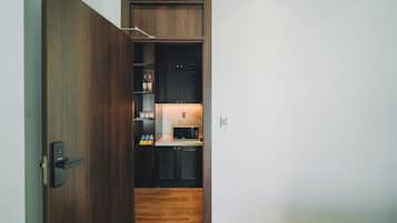 A modern kitchen with dark wood cabinets, a built-in microwave, and a small countertop.
