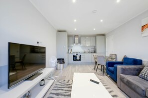 Relax in this cozy living space with a flat-screen TV, comfortable seating, and a dining area.