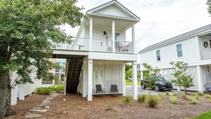 A two-story house with a covered porch and a stone pathway leading to the entrance. - Cozy cottage with easy access to beach & restaurants- Pet Friendly! (PASS CHRISTIN)