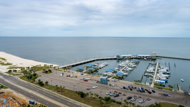 A marina with boats docked, a parking lot, and a road leading to the marina. - Cozy cottage with easy access to beach & restaurants- Pet Friendly! (PASS CHRISTIN)