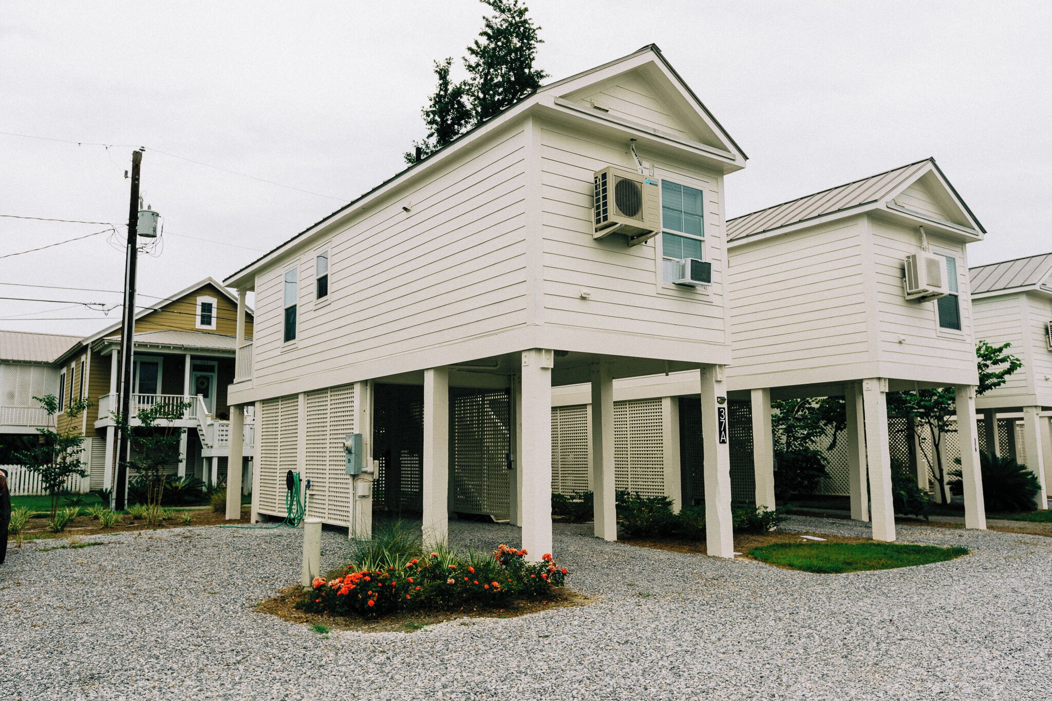 A two-story building with a covered porch and air conditioning units.