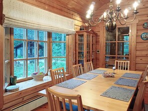 A wooden dining room with a large table, chairs, and a chandelier. - Lauluranta by Interhome (Padasjoki)