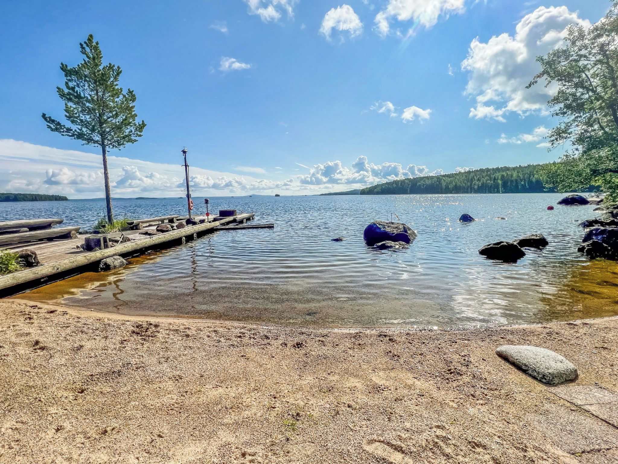 A lakeside dock with a clear view of the water and distant land.