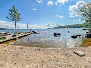 A lakeside dock with a clear view of the water and distant land.