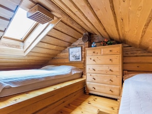 A wooden cabin room with a loft bed, a dresser, and a picture on the wall. - Lauluranta by Interhome (Padasjoki)