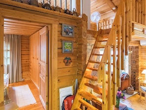 A wooden interior with a wooden staircase, a door leading to another room, and a small table with items on it. - Lauluranta by Interhome (Padasjoki)