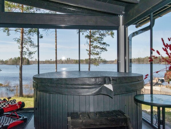 A hot tub with a view of a lake and trees.