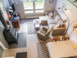 A modern living space with a sofa, armchair, dining table, and a fireplace.