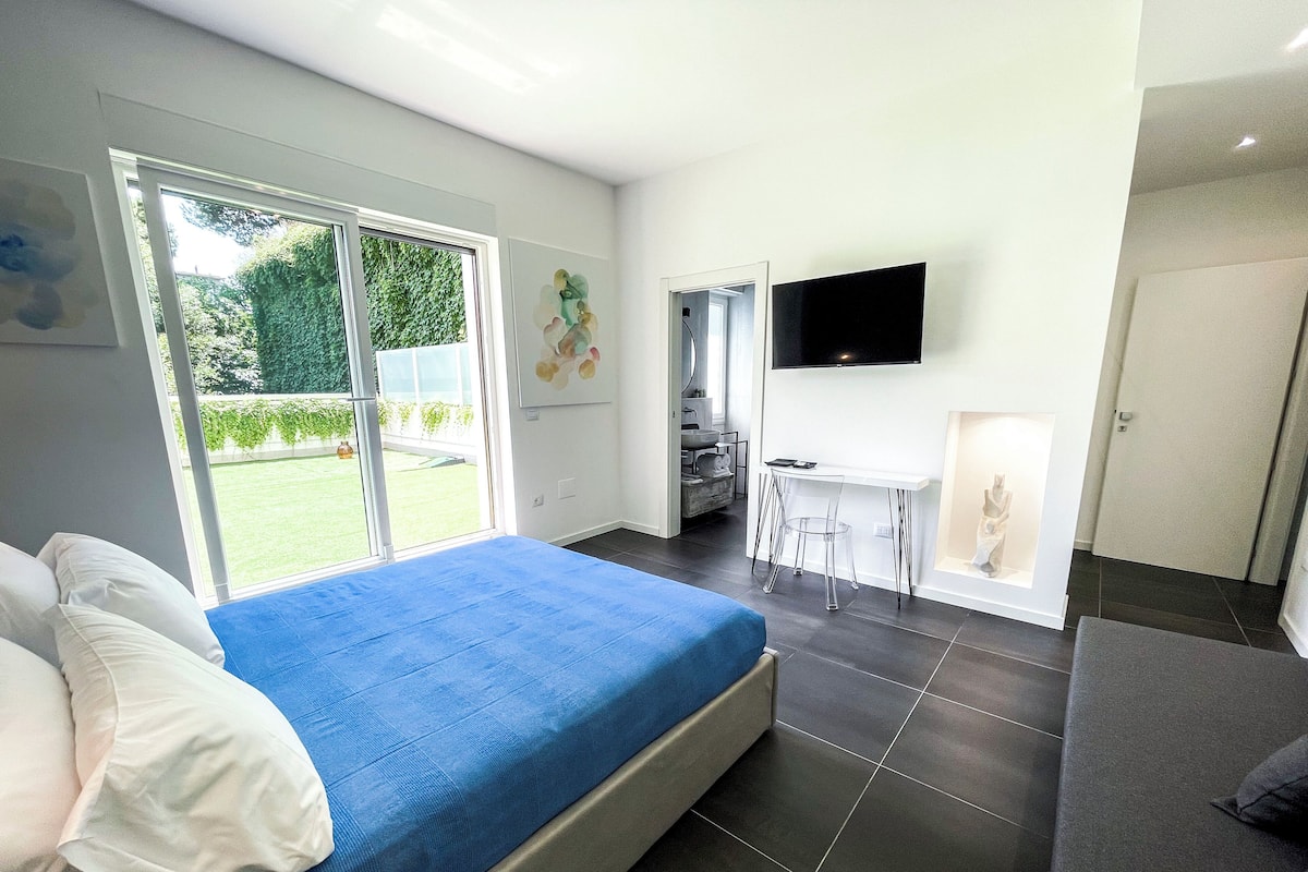 Un dormitorio moderno con una cama grande, un escritorio y un televisor.