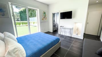 Une chambre moderne avec un grand lit, un bureau et un téléviseur.