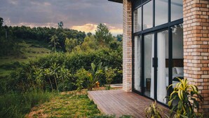 A modern house with a large glass door leading to a bedroom. - UMVA Muhazi (Muhazi)