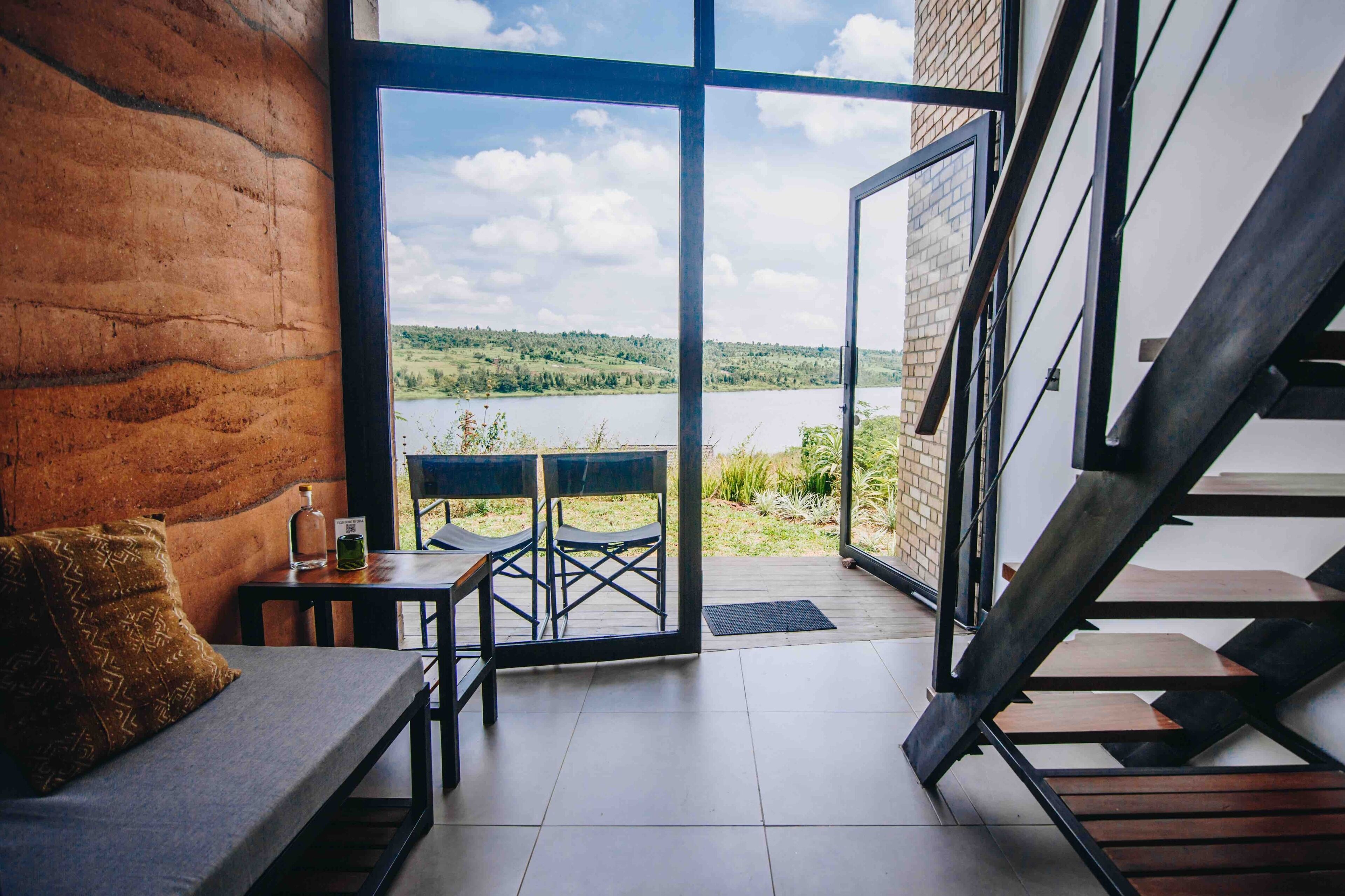 Un interior moderno con vistas a un lago y follaje.
