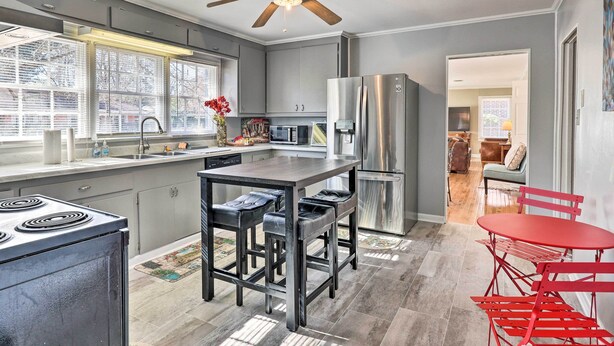 A modern kitchen with a central island, stainless steel appliances, and a ceiling fan. - Pine Bluff (Pine Bluff)