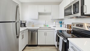 A modern kitchen with stainless steel appliances, white cabinetry, and a dishwasher. - Viridian Biltmore Villa with Pool (Phoenix)