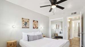 A bedroom with a bed, bedside lamps, a ceiling fan, and artwork on the wall. - Viridian Biltmore Villa with Pool (Phoenix)