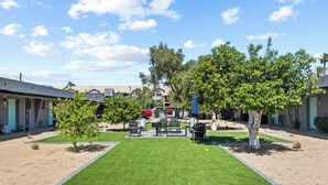 A courtyard with a central lawn, seating area, and trees. - Viridian Biltmore Villa with Pool (Phoenix)