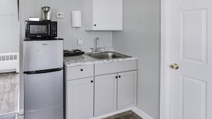 A compact kitchen with a Galanz refrigerator, a microwave, a sink, and white cabinets. - 2Bd Holiday Retreat Detroit Museums and Parks (Riverview)