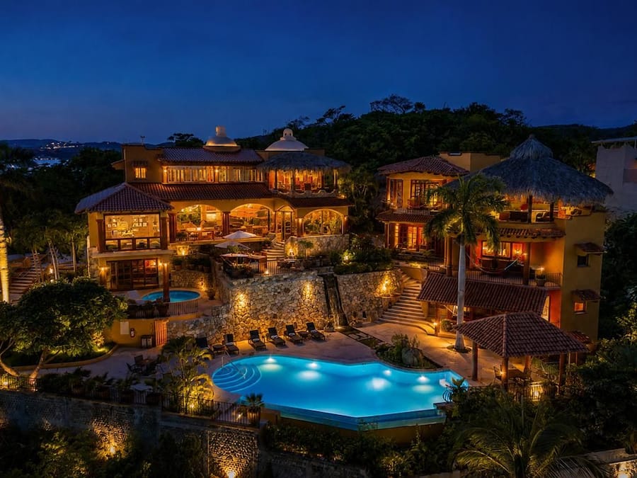 A resort with multiple buildings, a swimming pool, and outdoor seating areas.