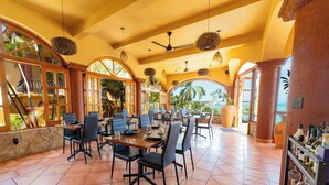 A spacious dining area with high ceilings, large windows, and a view of the ocean. - Casa Ceiba Huatulco - Adults Only (Santa María Huatulco)