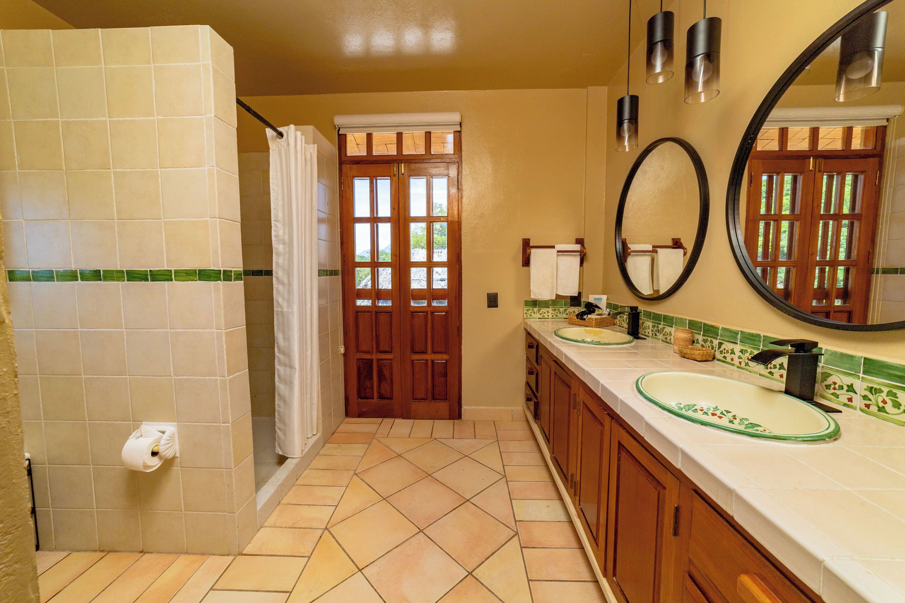 Ein Badezimmer mit Dusche, Toilette, Waschbecken und Spiegel.