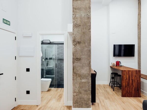 Un baño moderno con cabina de ducha de vidrio, inodoro y lavamanos.