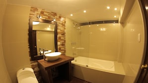 A modern bathroom with a glass-enclosed shower, a white toilet, and a vanity with a mirror. - La Estacion Cusco Hotel (Cusco)