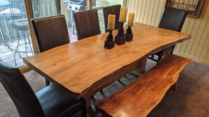 A wooden dining table with a bench, black leather chairs, and candle holders. - Cozy Condo at Seven Springs
 (Champion)