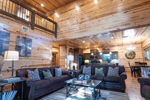 Relax in this cozy retreat with a leather sofa, armchair, and coffee table, plus a balcony with a railing and a modern kitchen.