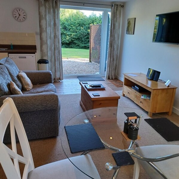 A modern living room with a sofa, coffee table, and TV stand.