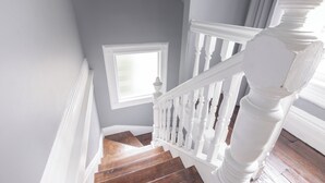 Una escalera con balaustres blancos y peldaños de madera.