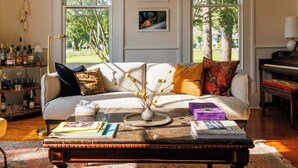 A living room with a sofa, coffee table, and a bookshelf. - Luxurious Family Escape with Small Town Charm (Montezuma)