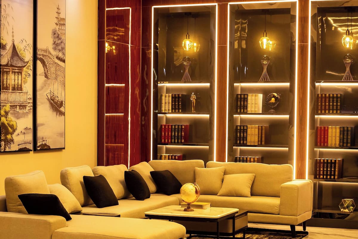 A modern living room with a sectional sofa, a coffee table, and a bookshelf.