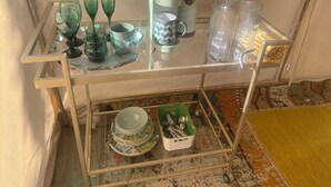 Ein Tisch mit Glasplatte, diverse Küchenutensilien und einer Kaffeemaschine.