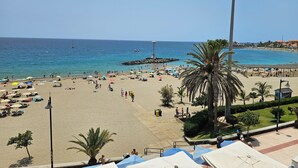 A beach with umbrellas, palm trees, and a clear blue sky. - Breathtaking sea view, only 100 m to the sea and the beach, heated pool, wifi (Playa de la Américas)