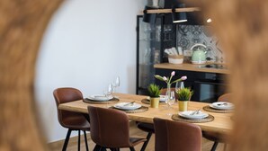 A dining area with a round table, six chairs, and a kitchen in the background. - Villa Nika (Novalja)