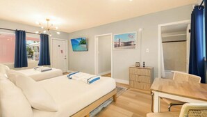 A hotel room with two beds, a wooden dining table, and a small cabinet. - 3 min to beach ~ 2 bed ~ pool ~ free parking (Clearwater)