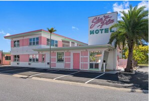 Un motel de diseño retro, con un gran letrero de neón.