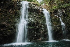 Une cascade se déversant sur une falaise rocheuse et se jetant dans un bassin.