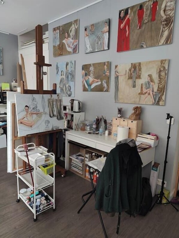 A studio with a large easel, art supplies, and multiple paintings on the wall. - Loft, artist's studio Montmartre, Loft, atelier artiste Montmartre (160m² / 1720sqft) (Paris)