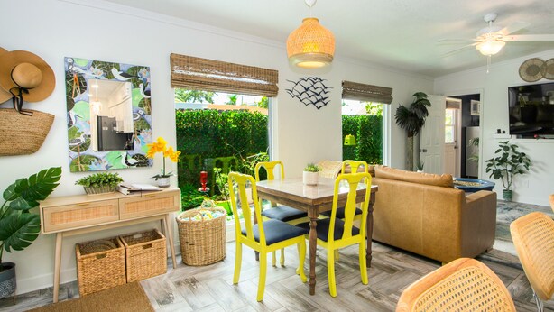 A dining area with yellow chairs, a wooden table, and a ceiling fan.