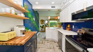 A modern kitchen with wooden countertops, white cabinets, and a built-in oven.